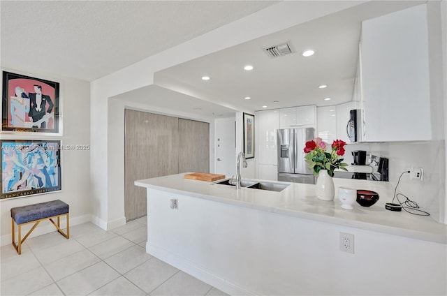 kitchen with white cabinets, sink, stainless steel appliances, and kitchen peninsula