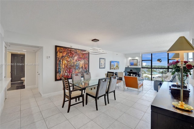 tiled dining room featuring a textured ceiling and expansive windows