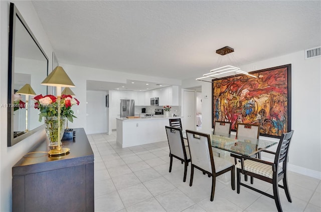 tiled dining space featuring a textured ceiling