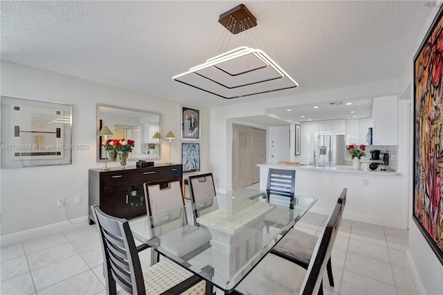 tiled dining space with a textured ceiling