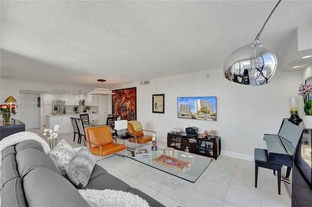 tiled living room with an inviting chandelier and a textured ceiling