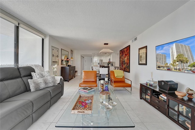 living room featuring a textured ceiling and light tile patterned flooring