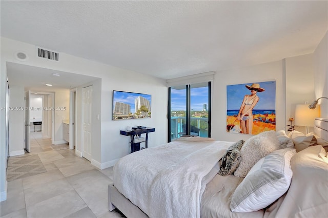 bedroom with access to exterior and a textured ceiling