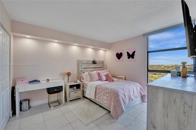 tiled bedroom featuring a textured ceiling