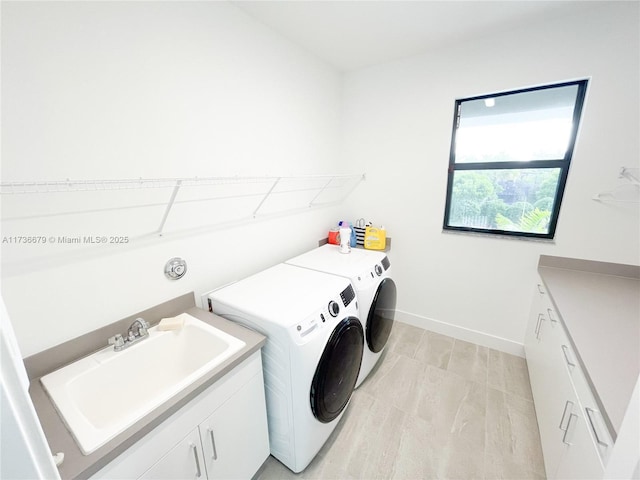 laundry area with cabinets, sink, and washing machine and clothes dryer