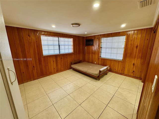 unfurnished bedroom featuring ornamental molding and wooden walls