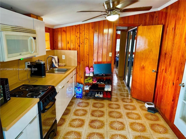 kitchen featuring ornamental molding, sink, white cabinets, and black appliances