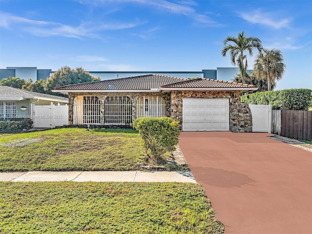 ranch-style house featuring driveway, a garage, stone siding, a tiled roof, and a gate