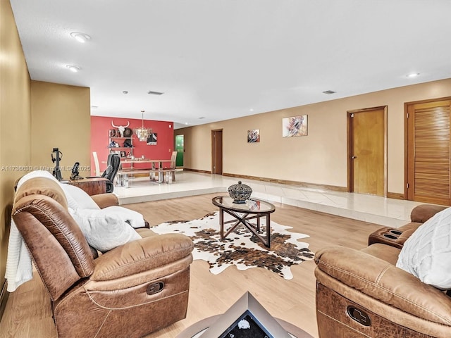 living room with light wood finished floors, visible vents, and baseboards