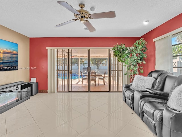 tiled living room featuring a ceiling fan and a textured ceiling