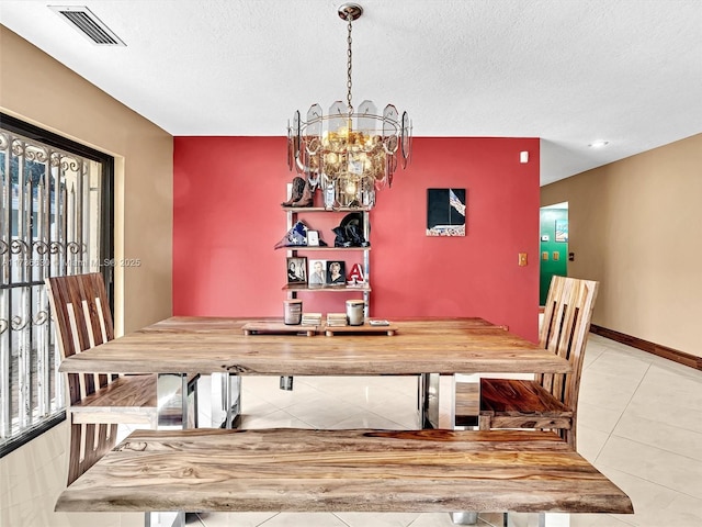 tiled dining area with baseboards, visible vents, a chandelier, and a textured ceiling