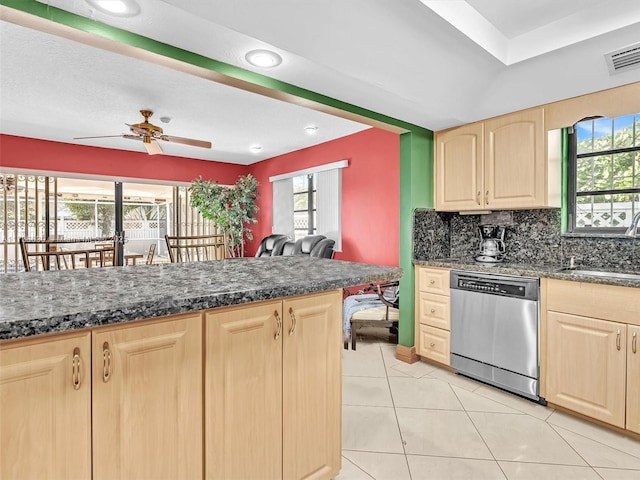 kitchen featuring visible vents, decorative backsplash, stainless steel dishwasher, light brown cabinets, and a sink