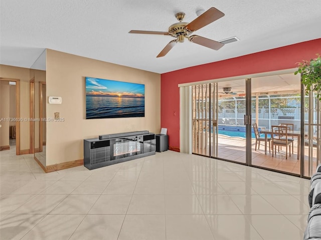 tiled living area with visible vents, ceiling fan, a textured ceiling, and baseboards