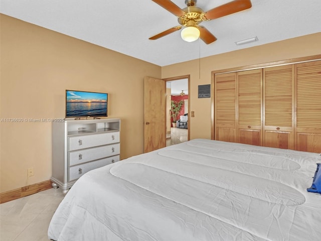 bedroom with light tile patterned floors, baseboards, visible vents, ceiling fan, and a closet