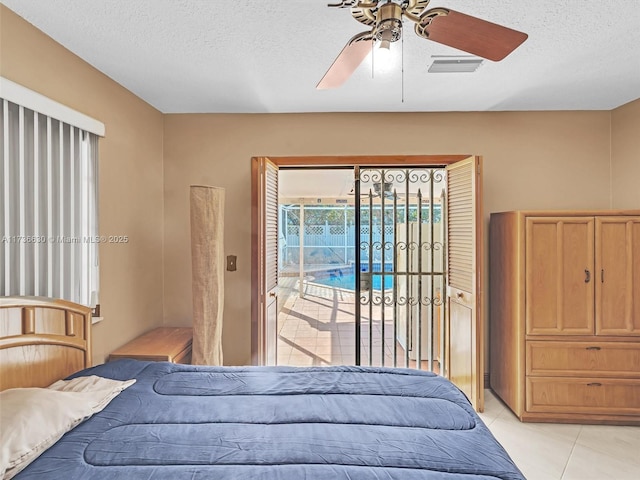 bedroom with light tile patterned floors, ceiling fan, a textured ceiling, and access to exterior