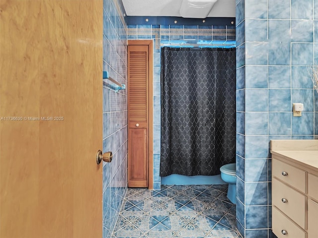 bathroom with a shower with curtain, tile walls, toilet, and tile patterned floors