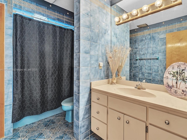 full bathroom featuring tile walls, curtained shower, toilet, vanity, and tile patterned flooring