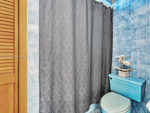 bathroom featuring a shower with curtain and toilet