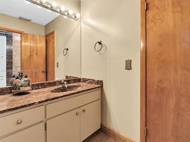 bathroom with visible vents, vanity, and baseboards