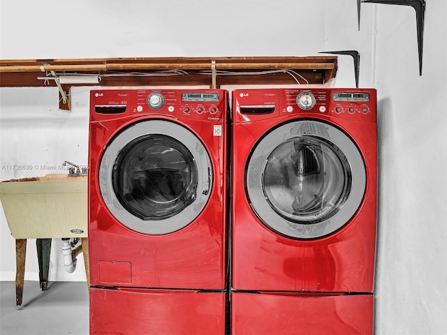 clothes washing area featuring laundry area, separate washer and dryer, and a sink