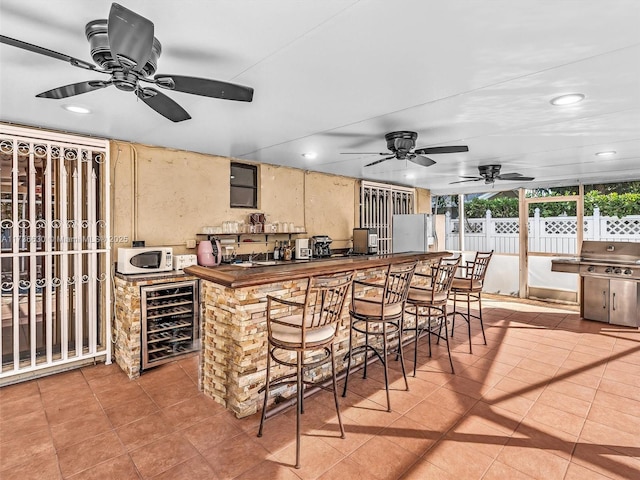 exterior space featuring white appliances, tile patterned flooring, wine cooler, and recessed lighting