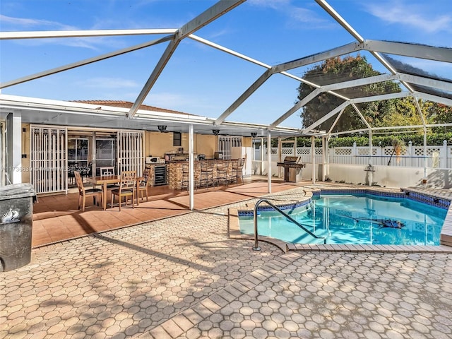 view of swimming pool with glass enclosure, fence, a fenced in pool, and a patio