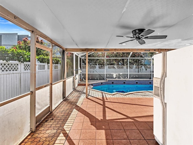 unfurnished sunroom featuring a jacuzzi and a ceiling fan