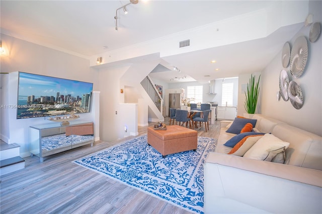 living room featuring crown molding, hardwood / wood-style floors, and track lighting