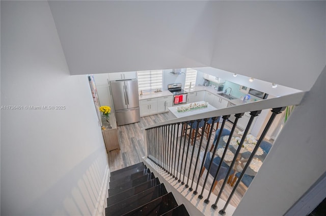 stairway featuring sink and hardwood / wood-style floors