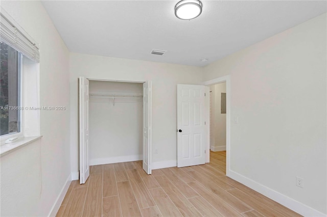 unfurnished bedroom featuring a closet and light wood-type flooring