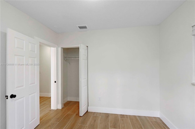 unfurnished bedroom with light hardwood / wood-style floors and a closet