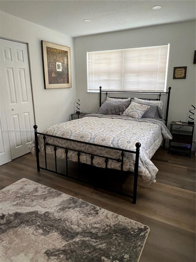 bedroom featuring dark hardwood / wood-style flooring and a closet