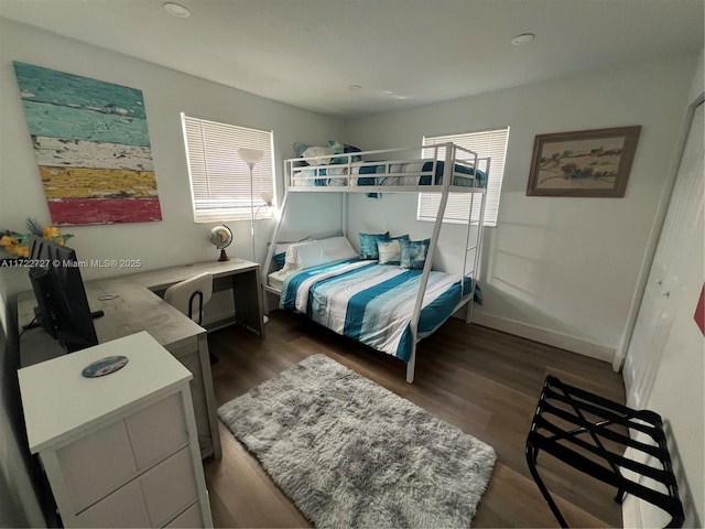 bedroom featuring multiple windows, baseboards, and dark wood-style flooring