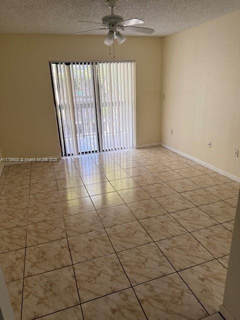 tiled empty room with ceiling fan and a textured ceiling