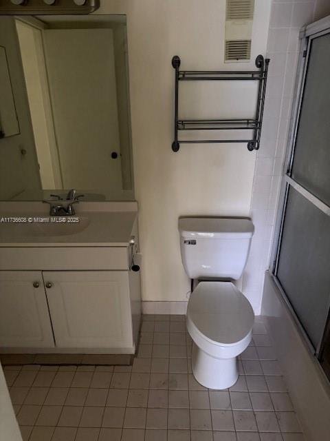 full bathroom with enclosed tub / shower combo, vanity, toilet, and tile patterned floors