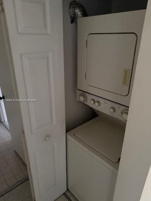 washroom with stacked washer and dryer and light tile patterned floors