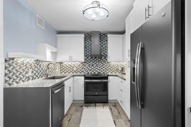 kitchen with white cabinetry, sink, decorative backsplash, stainless steel appliances, and wall chimney exhaust hood