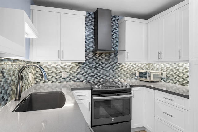 kitchen featuring range with electric stovetop, white cabinetry, sink, decorative backsplash, and wall chimney exhaust hood