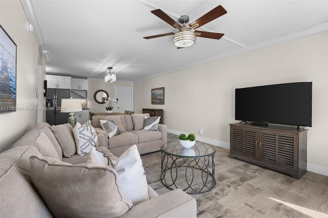 living room featuring crown molding, ceiling fan, and light wood-type flooring