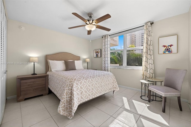 tiled bedroom featuring ceiling fan