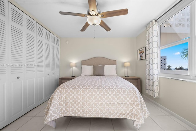 tiled bedroom with ceiling fan and a closet