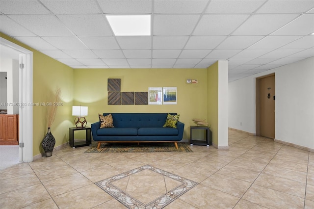 tiled living room featuring a drop ceiling