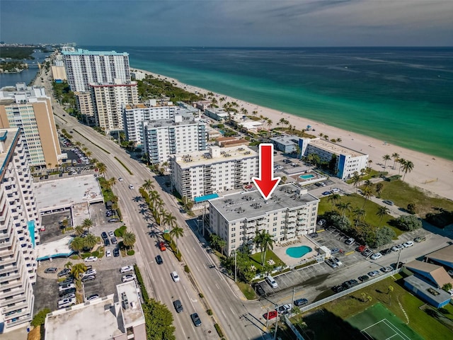 drone / aerial view featuring a beach view and a water view