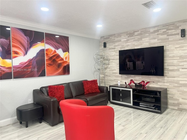 living room featuring ornamental molding, wood-type flooring, and a textured ceiling