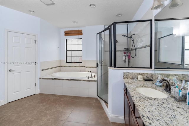 bathroom featuring tile patterned flooring, vanity, separate shower and tub, and a textured ceiling