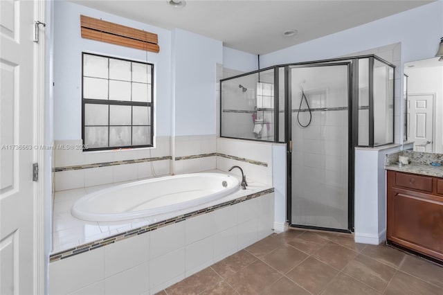 bathroom featuring independent shower and bath, vanity, and tile patterned floors