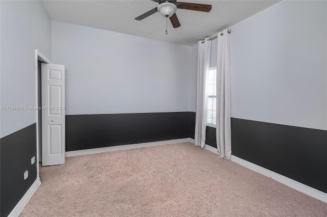 carpeted empty room with ceiling fan and a textured ceiling