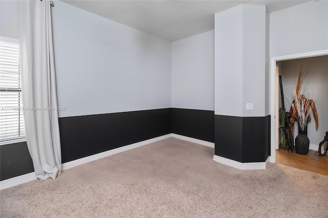 unfurnished room with a textured ceiling and carpet flooring