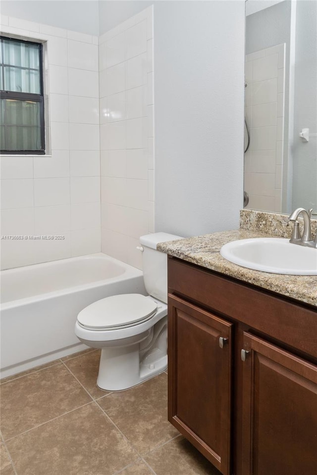 full bathroom featuring vanity, tiled shower / bath, tile patterned floors, and toilet