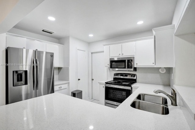 kitchen featuring stainless steel appliances, sink, and white cabinets